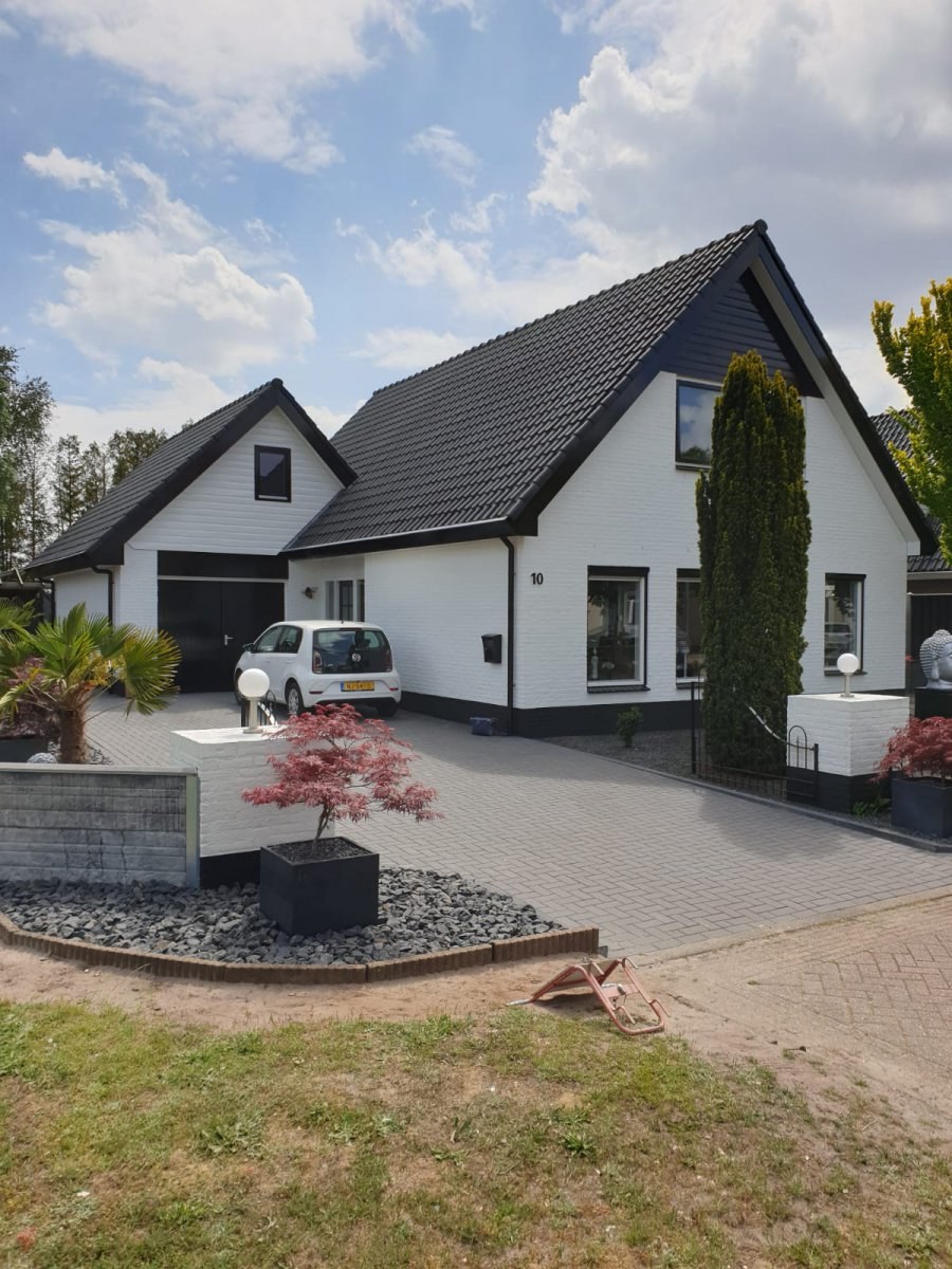 Witte woning met garage en donkere kozijnen